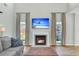 Living room featuring a fireplace, mounted TV, large windows, and comfortable seating at 9670 Pebble Creek Blvd, Summerville, SC 29485