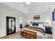 Well-lit primary bedroom features hardwood floors, decorative mirrors, and comfortable bedding at 9670 Pebble Creek Blvd, Summerville, SC 29485