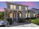 Rear of the house with a screened porch, patio, manicured lawn, and outdoor lighting at 9670 Pebble Creek Blvd, Summerville, SC 29485
