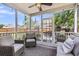 This screened-in back porch is nicely decorated with outdoor furniture, overhead lighting, and a ceiling fan at 9670 Pebble Creek Blvd, Summerville, SC 29485
