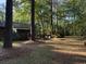 Spacious backyard with mature trees, outdoor seating area and an umbrella at 1020 Welles Ln, Walterboro, SC 29488
