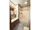Well-lit bathroom with a single sink vanity and a shower-tub combination, accented by blue rugs and wood trim at 1020 Welles Ln, Walterboro, SC 29488