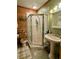 Bright bathroom featuring corner shower, pedestal sink, and unique wood paneling at 1020 Welles Ln, Walterboro, SC 29488