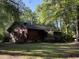 Charming log cabin exterior surrounded by lush greenery and mature trees in a tranquil setting at 1020 Welles Ln, Walterboro, SC 29488