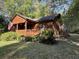 Beautiful log cabin featuring a cozy front porch and mature landscaping, enhancing the home's rustic charm at 1020 Welles Ln, Walterboro, SC 29488