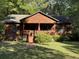Charming log cabin featuring a cozy front porch with an American flag, inviting curb appeal and mature landscaping at 1020 Welles Ln, Walterboro, SC 29488