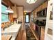 Functional kitchen with stainless steel appliances, light wood cabinets, and an elongated layout leading to an exterior door at 1020 Welles Ln, Walterboro, SC 29488