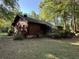 Rustic log cabin featuring a charming screened-in porch, nestled in a tranquil, tree-filled setting, enhancing its appeal at 1020 Welles Ln, Walterboro, SC 29488