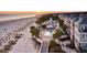 Breathtaking aerial view of oceanfront community, showcasing the beach, pool, and colorful homes at 103 Grand Pavilion Blvd, Isle of Palms, SC 29451