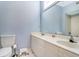 Bright bathroom featuring double sinks with white countertop, large mirror, white tiled floors, and blue walls at 103 Grand Pavilion Blvd, Isle of Palms, SC 29451