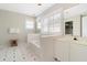 Bathroom with a tiled bathtub, white cabinetry, patterned flooring, and plantation shutters for natural light at 103 Grand Pavilion Blvd, Isle of Palms, SC 29451