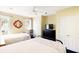 Bright bedroom featuring two beds, a ceiling fan, and a decorative red mirror against the yellow-painted wall at 103 Grand Pavilion Blvd, Isle of Palms, SC 29451