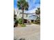 Coastal home featuring unique architectural details, brick foundation, convenient parking, and lush landscaping at 103 Grand Pavilion Blvd, Isle of Palms, SC 29451