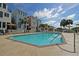 Inviting community pool surrounded by colorful buildings, lounge chairs, and umbrellas under a sunny sky at 103 Grand Pavilion Blvd, Isle of Palms, SC 29451