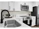 Bright kitchen with white cabinets, black hardware, stainless appliances, and white marble countertops at 105 Brailsford Rd, Summerville, SC 29485