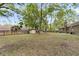 Large backyard with mature trees, shed, brick home, and a wooden privacy fence, perfect for outdoor activities at 106 Spring Farm Pl, Summerville, SC 29485
