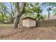 View of a storage shed situated in a backyard with a wooden fence and mature trees at 106 Spring Farm Pl, Summerville, SC 29485
