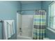 Tiled bathroom with tub, shower, window, and striped shower curtain at 107 Towering Pine Dr, Ladson, SC 29456