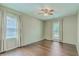 Bedroom with wood floors, two windows with curtains, and a ceiling fan at 109 Winston Way, Goose Creek, SC 29445