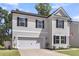 Charming two-story home with a manicured lawn, attached garage and inviting front porch with dark door at 1167 Mossy Rock Dr, Summerville, SC 29485