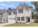 Charming two-story home with a manicured lawn, attached garage and inviting front porch with dark door at 1167 Mossy Rock Dr, Summerville, SC 29485
