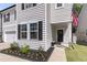 Close-up of the inviting front porch with a dark door, green plants, and a manicured lawn at 1167 Mossy Rock Dr, Summerville, SC 29485