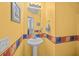 Bright yellow half bathroom featuring floral accents and a pedestal sink at 1218 Cosmos Rd, Summerville, SC 29483