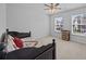 Bright bedroom with two windows, ceiling fan, neutral carpet and black sleigh bed at 1218 Cosmos Rd, Summerville, SC 29483