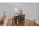 A formal dining room features hardwood floors, a window with blinds, and a classic chandelier at 1218 Cosmos Rd, Summerville, SC 29483