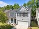 Charming two-story home featuring gray siding, black shutters, a well-manicured lawn, and a two-car garage at 1218 Cosmos Rd, Summerville, SC 29483