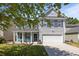 Charming two-story home featuring gray siding, black shutters, a well-manicured lawn, and a two-car garage at 1218 Cosmos Rd, Summerville, SC 29483