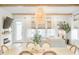 Light-filled dining room with modern light fixture, white table, and views of the living room at 127 Archdale St, Summerville, SC 29486