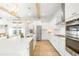 Bright kitchen features white cabinets, stainless steel appliances, large island, and stylish gold pendant lighting at 127 Archdale St, Summerville, SC 29486