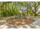 Outdoor firepit area with Adirondack chairs nestled beneath mature trees creating a relaxing gathering space at 1303 Teal Ave, Charleston, SC 29412
