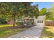 Charming white home with a brick facade, adorned with an American flag and mature trees at 1303 Teal Ave, Charleston, SC 29412