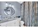 Modern bathroom with a white vanity, decorative mirror, and shower with stylish patterned curtain at 136 Cooper River Dr, Mount Pleasant, SC 29464