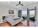 Bright bedroom featuring hardwood floors, ceiling fan, and balcony access with water views at 136 Cooper River Dr, Mount Pleasant, SC 29464