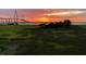 Scenic marsh view with a vibrant sunset and bridge in the distance, showcasing the natural beauty of the location at 136 Cooper River Dr, Mount Pleasant, SC 29464