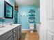 Bright bathroom with double vanity, tile floors, blue walls, tub, and open shelving for towels at 138 Avalon Rd, Summerville, SC 29483