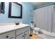 Well-lit bathroom featuring a classic vanity, toilet, and shower with a striped curtain at 138 Avalon Rd, Summerville, SC 29483