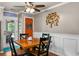 Inviting dining room featuring a wooden table, four chairs, wainscoting, and a colorful orange door at 138 Avalon Rd, Summerville, SC 29483