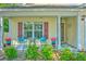 Close up of covered porch with outdoor seating and colorful planters, adding charm to the home's entrance at 138 Avalon Rd, Summerville, SC 29483