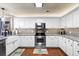 Well-lit kitchen showcasing white cabinets, granite counters, stainless steel appliances and hardwood floors at 138 Avalon Rd, Summerville, SC 29483