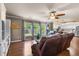 Open-concept living room showcases hardwood flooring, a ceiling fan, large windows and a view to kitchen at 138 Avalon Rd, Summerville, SC 29483