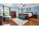 Stylish bedroom with a dark wood sleigh bed, tufted bench, area rug, and natural light from two windows at 138 Avalon Rd, Summerville, SC 29483