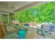 Inviting covered outdoor patio featuring a fire pit, wicker seating, and a dining area surrounded by lush greenery at 138 Avalon Rd, Summerville, SC 29483