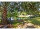 Idyllic pond view featuring a shaded bench beneath a palm tree, perfect for relaxation and enjoying nature at 1415 Inland Creek Way, Mount Pleasant, SC 29464