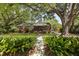 Beautiful brick home under mature trees with lush landscaping, featuring a welcoming front walkway at 1514 Gardenia Rd, Charleston, SC 29407