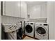 Laundry area with a washer, dryer, storage cabinets, and white trim at 1514 Gardenia Rd, Charleston, SC 29407