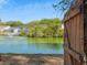 Scenic view of pond with fountain and backyard access through rustic wooden gate on a sunny day at 1516 Blaze Ln, Charleston, SC 29412